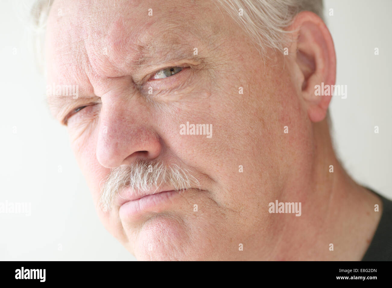 Älteren Mann mit einem verdächtigen oder skeptisch Ausdruck Stockfoto