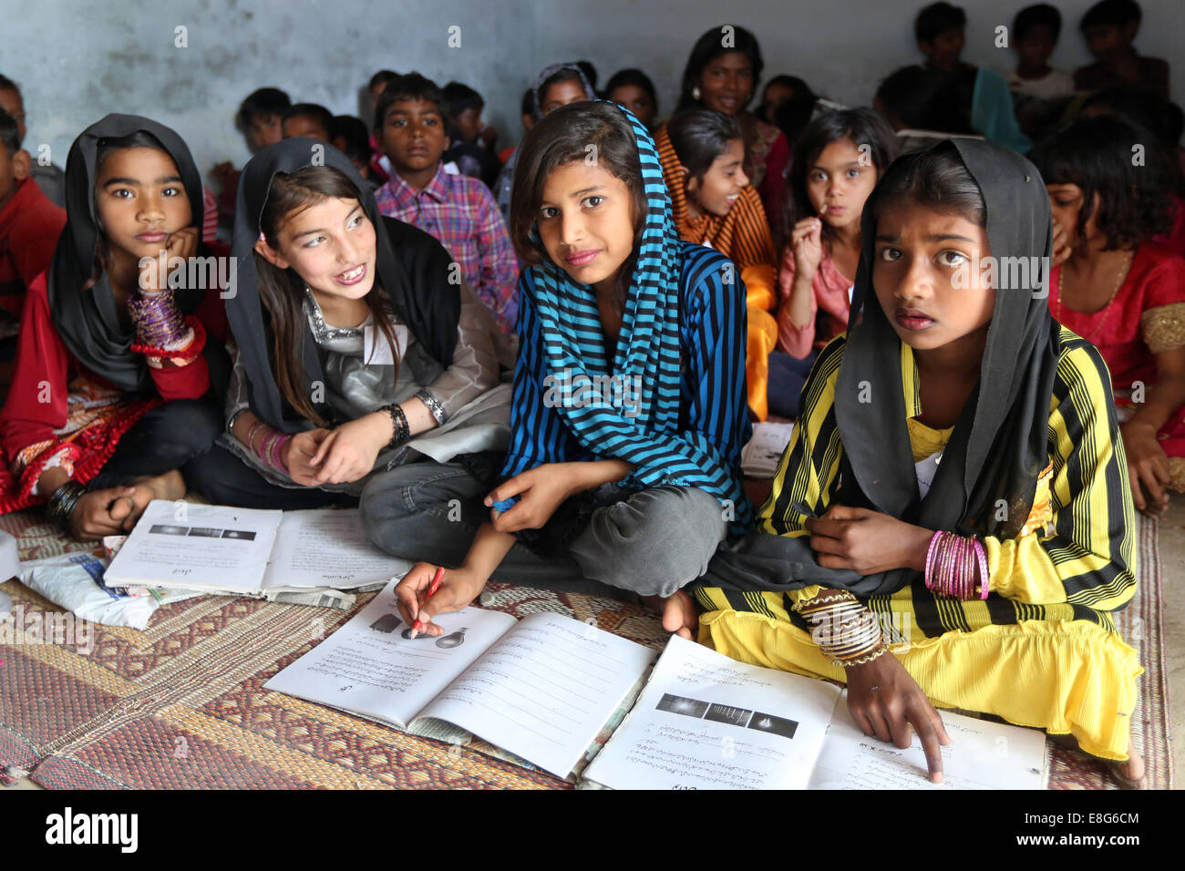 Kinder mit ihren Büchern in einem Klassenzimmer einer Schule in einem Dorf in der Nähe von Faisalabad, Pakistan Stockfoto
