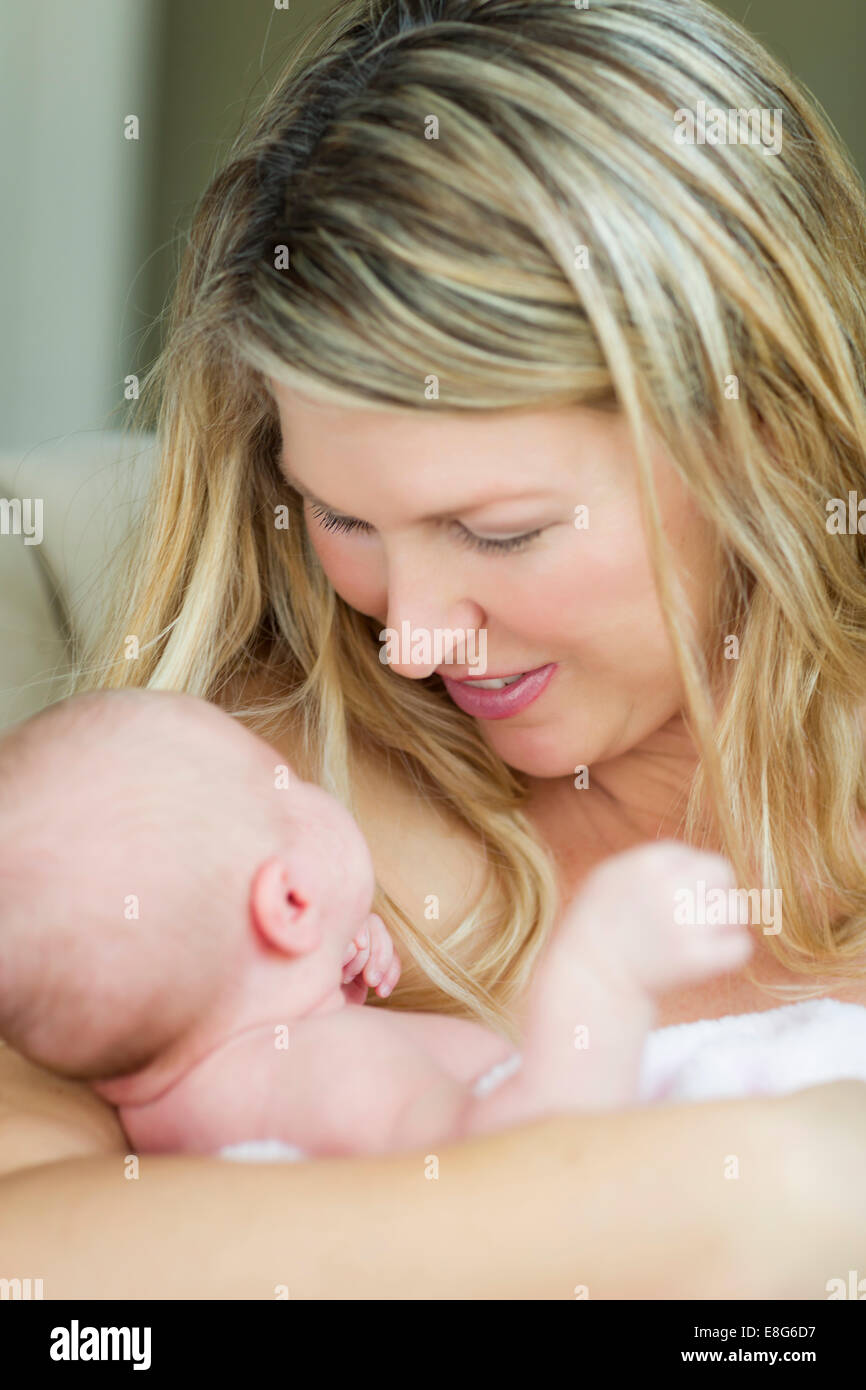 Junge kaukasischen schöne Mutter hält ihr kostbares neugeborenes Baby Girl. Stockfoto