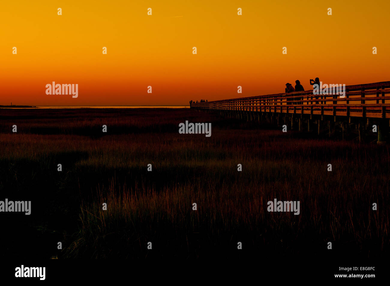 Touristen beobachten Sie den Sonnenuntergang von einem Pier in Dennis, Massachusetts, USA. Stockfoto