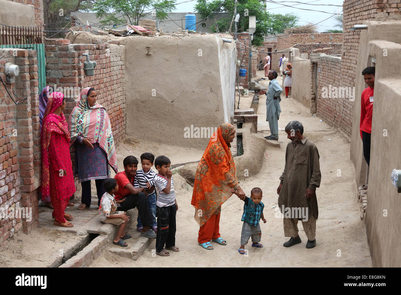 Dorfbewohner zwischen Lehmhäuser in einem Dorf in der Nähe von Faisalabad, Pakistan Stockfoto
