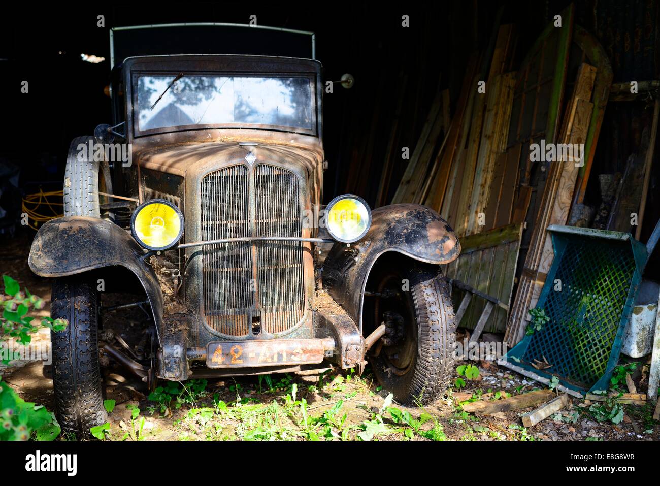 Ein Alter Renault van sitzt in einem Schuppen mit Holz gestapelt daneben Stockfoto