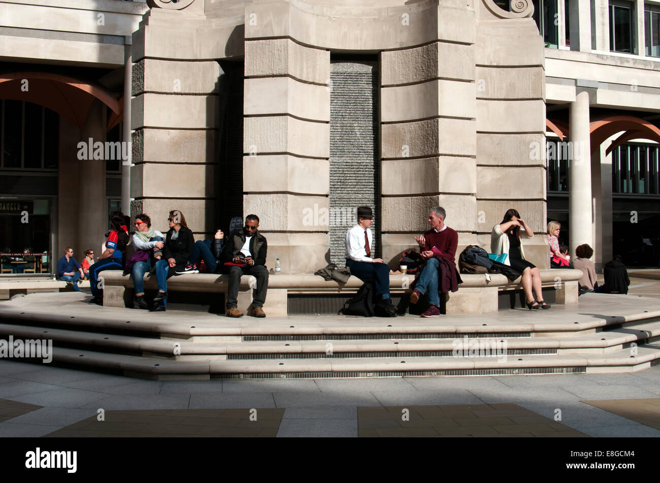 Leute sitzen auf Basis der Spalte Paternoster Square, London, UK Stockfoto