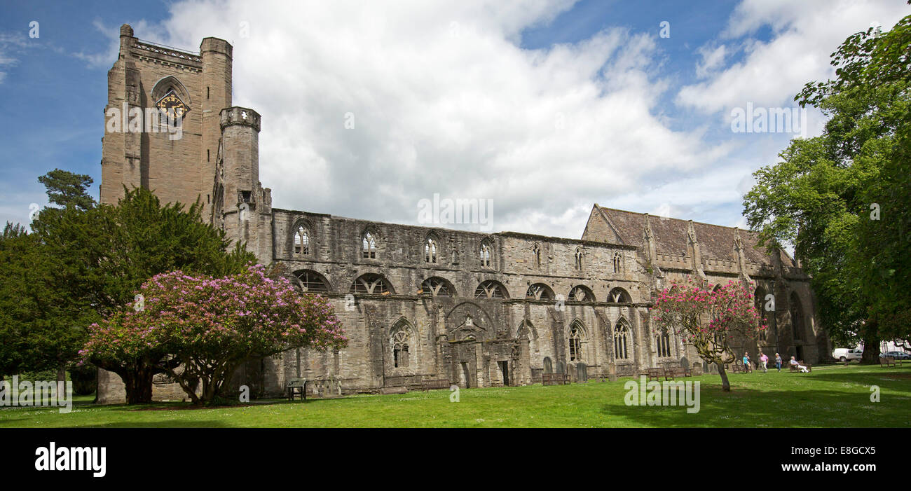 Historische Dunkeld Kathedrale, teilweise in Ruinen, umgeben von Gärten mit Rasen, blühenden Sträuchern, Bäumen, blauer Himmel, Scotlland Stockfoto