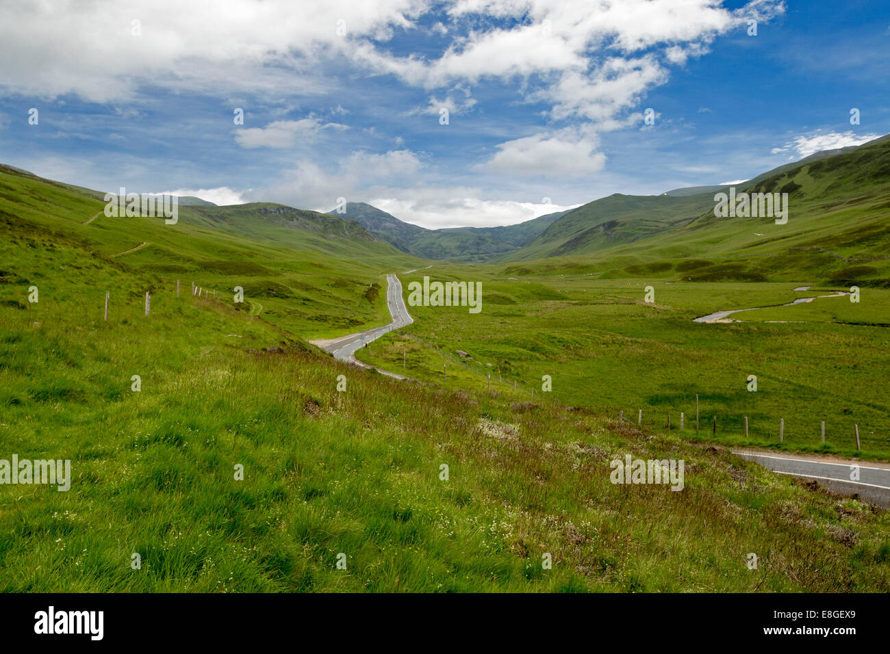 Spektakuläre weite Landschaft & schmale Straße schlängelt sich durch die sanften, grünen Hügeln & Berge der Cairngorms National Park, Schottland Stockfoto