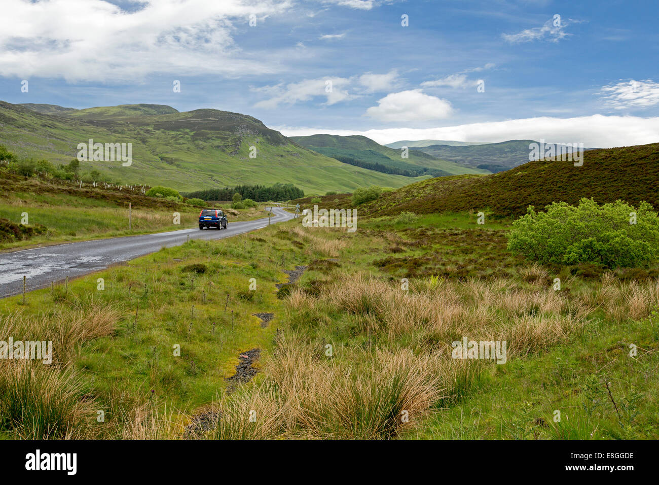 Malerische Landschaft mit Auto auf schmale Straße schlängelt sich durch die grünen Hügeln, Heide und Moorlandschaften der schottischen highlands Stockfoto