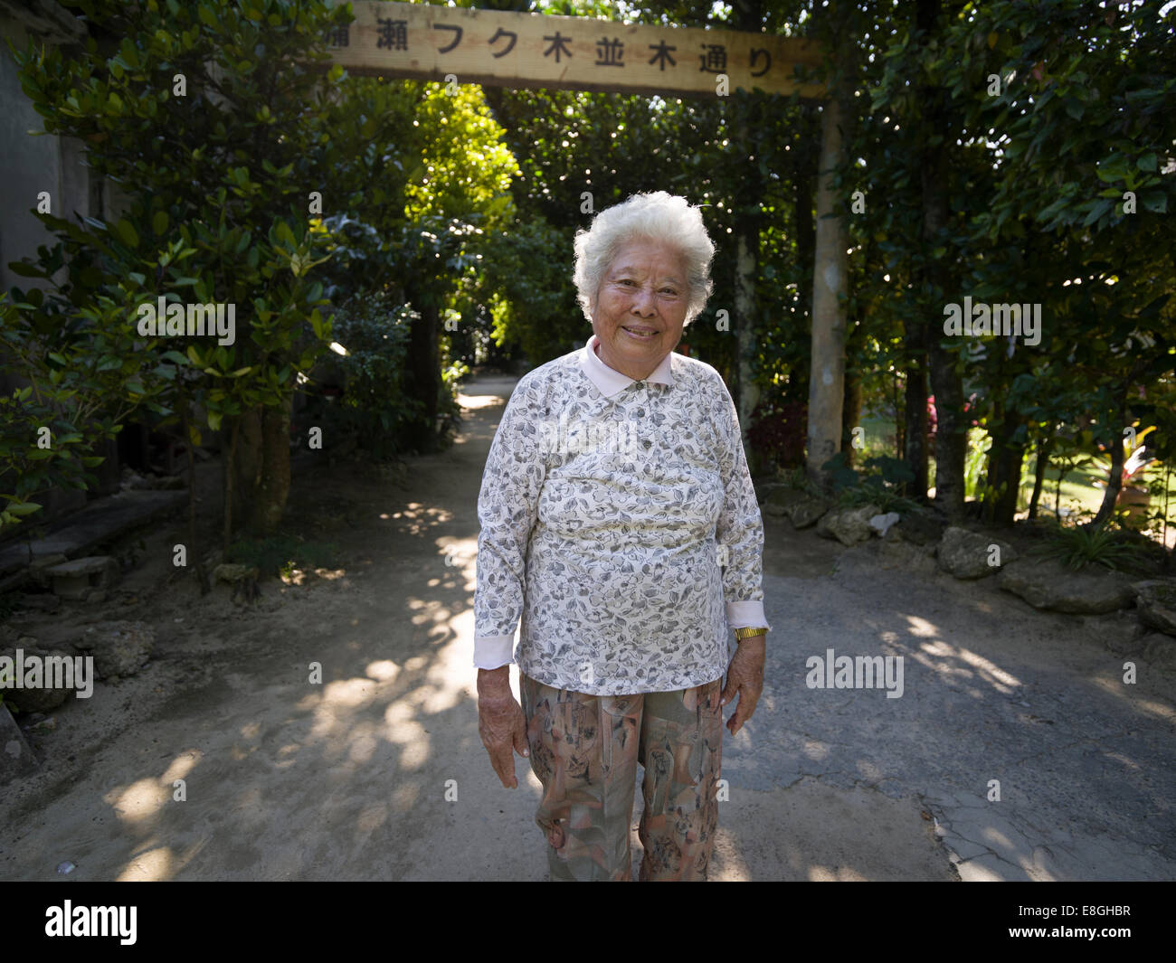 Lokalen Okinawan Seniorin bei Bise Fukugi Tree Road, Motobu, Okinawa. Okinawa Frauen haben weltweit längste Lebenserwartung Stockfoto