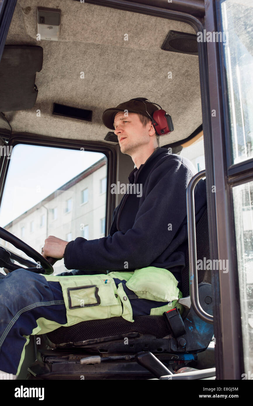 Seitenansicht der Bauarbeiter fahren Bagger am Standort Stockfoto