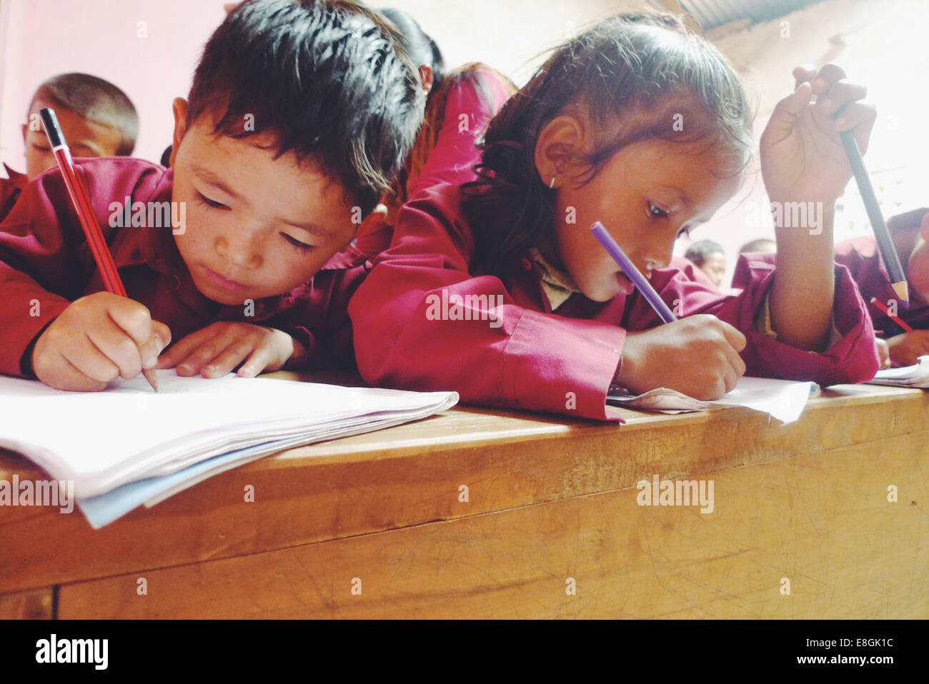 Schulkinder schreiben im Klassenzimmer, Nepal Stockfoto