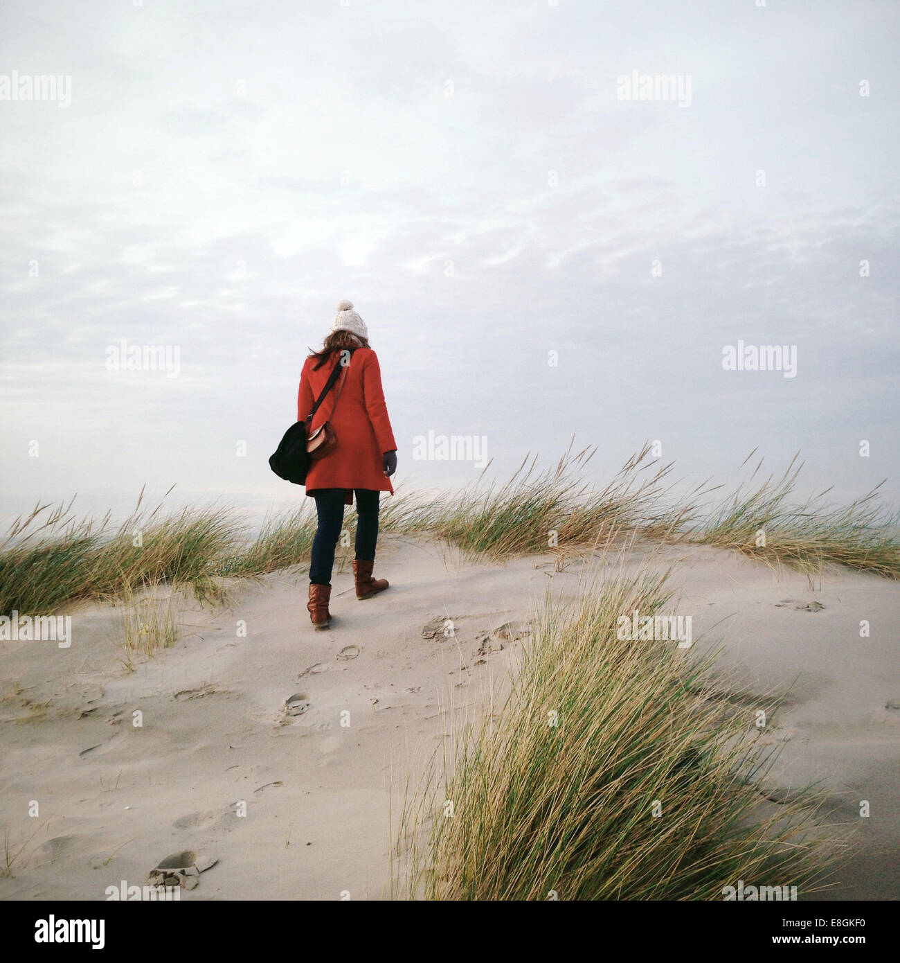 Rückansicht einer Frau, die im Winter am Strand spazieren geht, Strandslag 12, Duindorp Strand, Niederlande Stockfoto