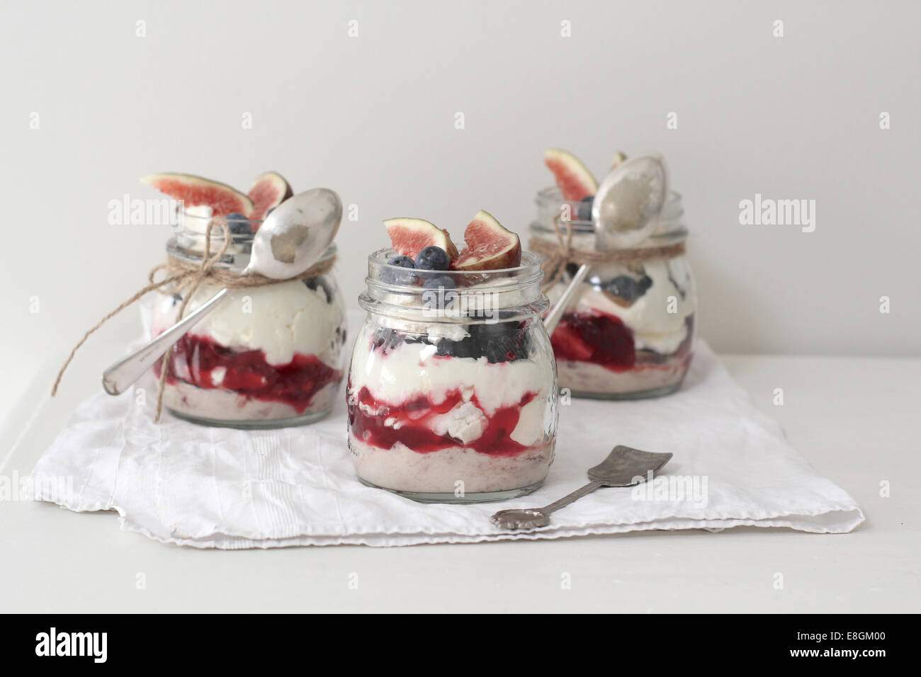Eton Mess Desserts in Gläsern, garniert mit frischen Feigen und Heidelbeeren Stockfoto