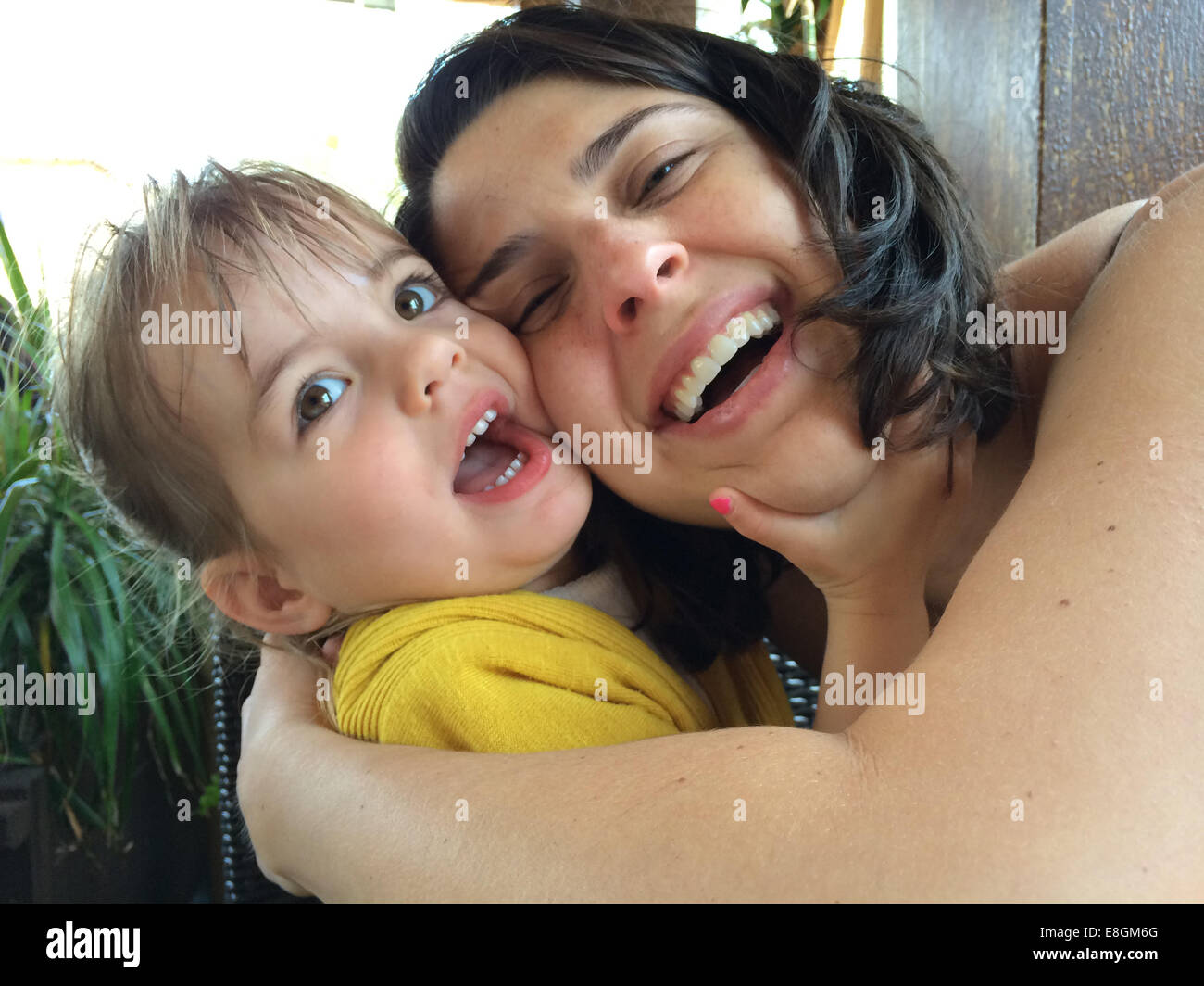 Mutter und Tochter (18-23 Monate) umarmen und lachen Stockfoto