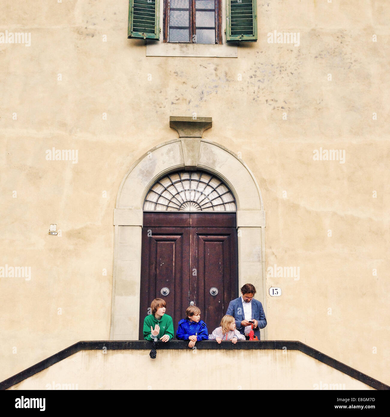 Vater und drei Kinder stehen vor einem Gebäude, Florenz, Toskana, Italien Stockfoto