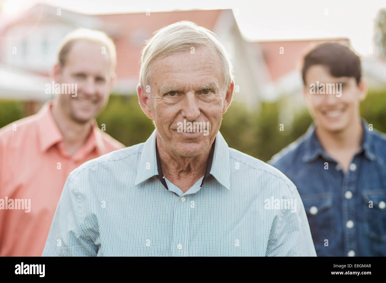 Porträt von zuversichtlich senior Mann mit Sohn und Enkel im Hof stehen Stockfoto