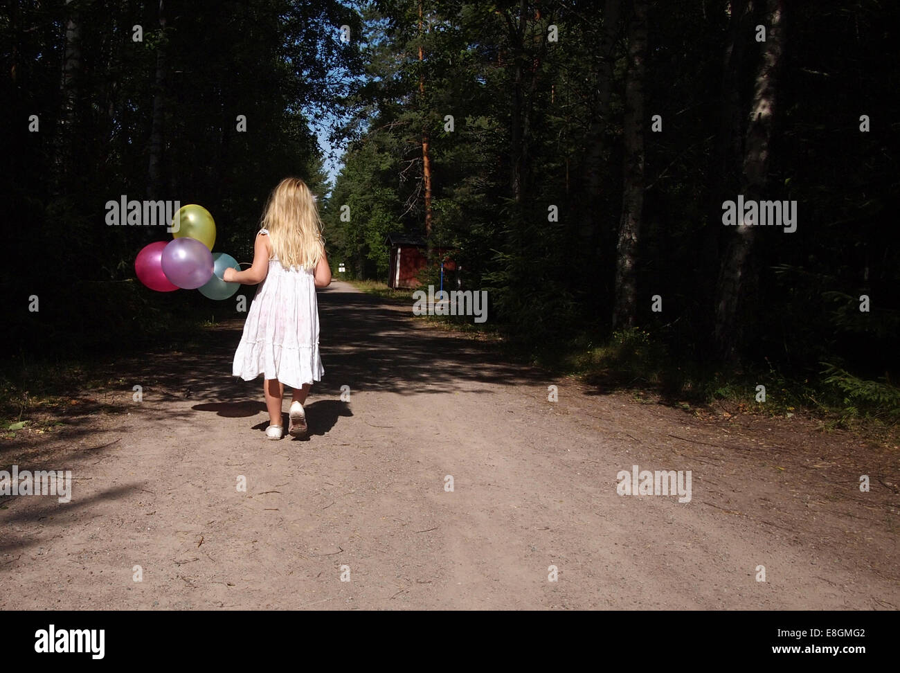 Mädchen, die die Straße hinunter mit einem Haufen Ballons, Schweden Stockfoto