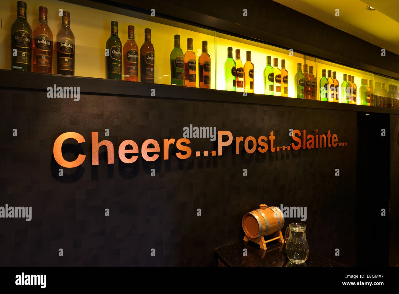 Whiskeyflaschen und Schriftzug "Prost, Prost und Slaínte" im Showroom von der Glenfiddich Whiskybrennerei in Dufftown, Moray Stockfoto