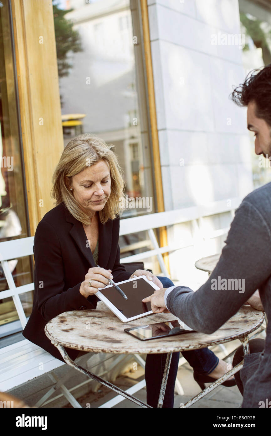 Mit digital-Tablette am Straßencafé Geschäftskollegen Stockfoto