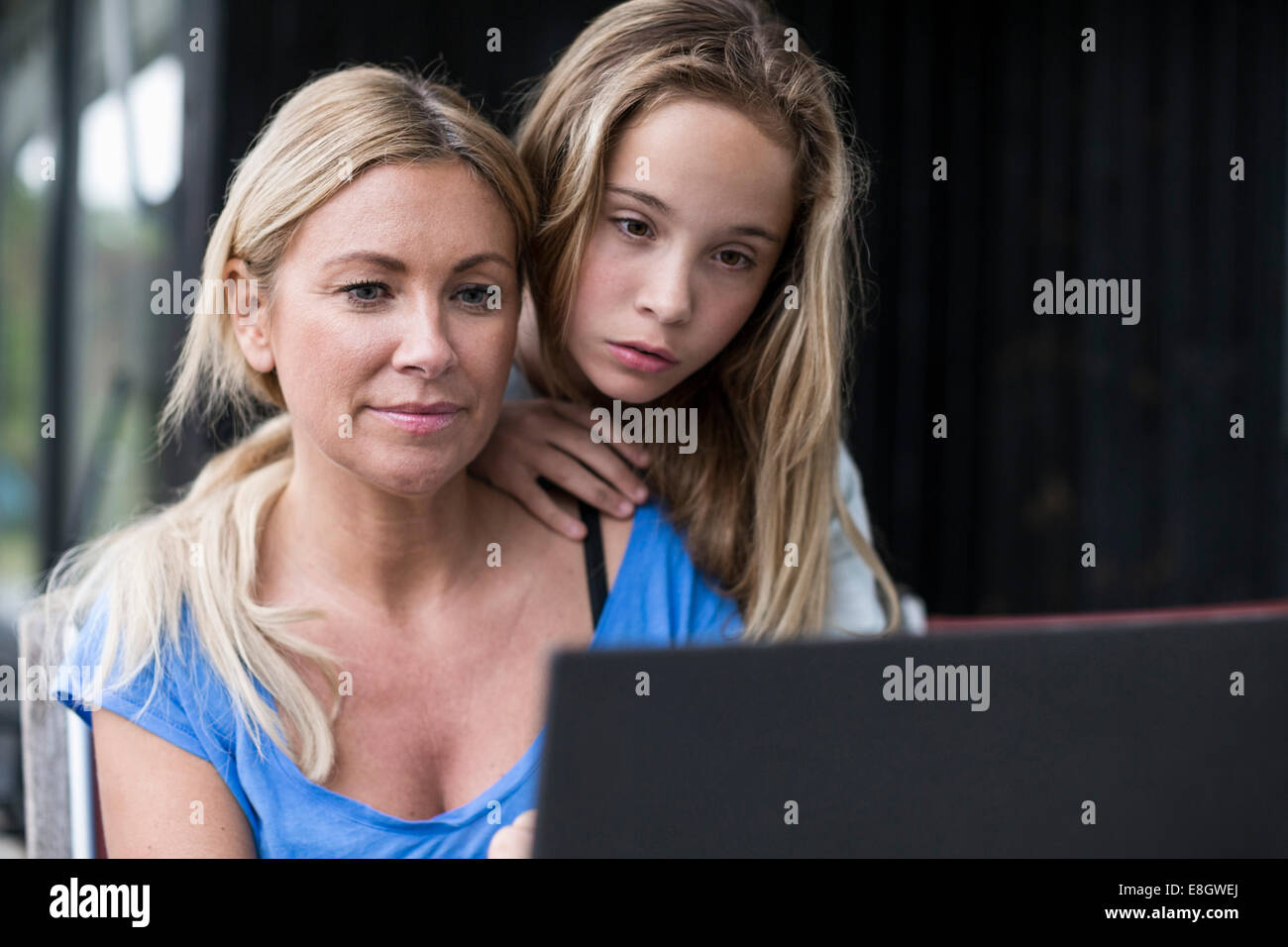 Mutter und Tochter mit Laptop am Hof Stockfoto