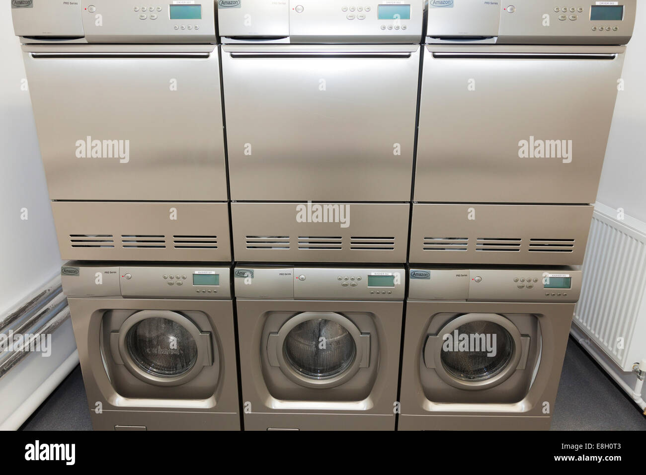 Stapel von Waschmaschinen und Wäschetrocknern in Gemeinschaftswaschküche. Stockfoto