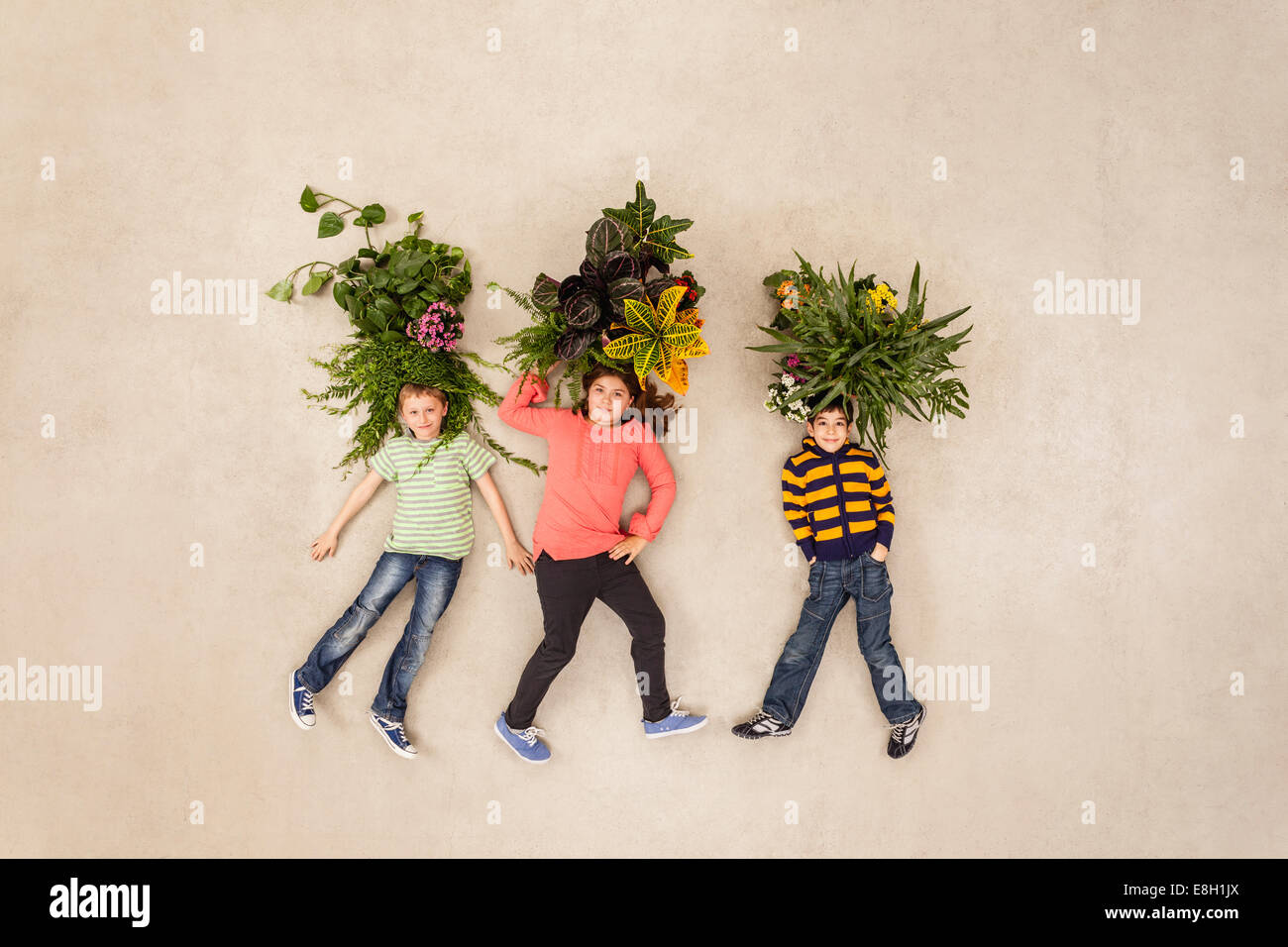 Kinder mit Pflanzen wachsen aus ihren Köpfen Stockfoto