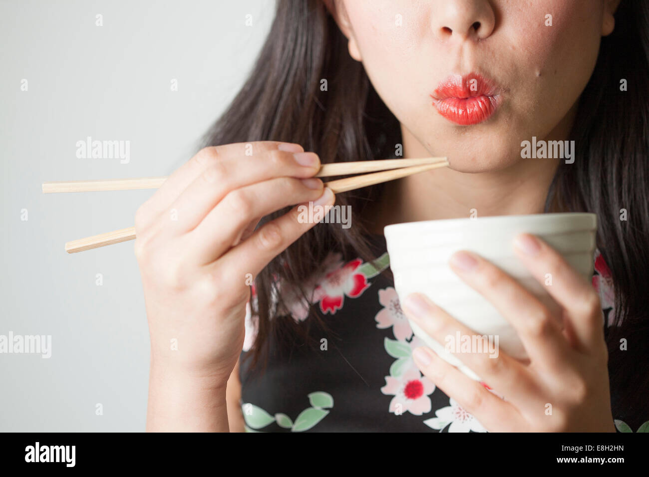 Asiatische Frau Essen mit Stäbchen Stockfoto