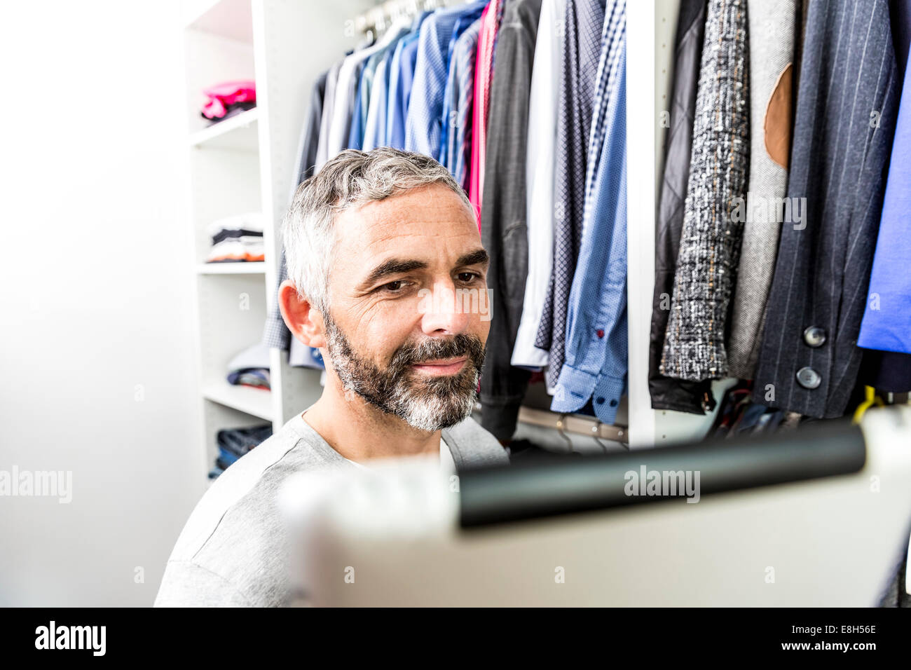 Mann mit seiner digital-Tablette Stand an seinem begehbaren Kleiderschrank Stockfoto