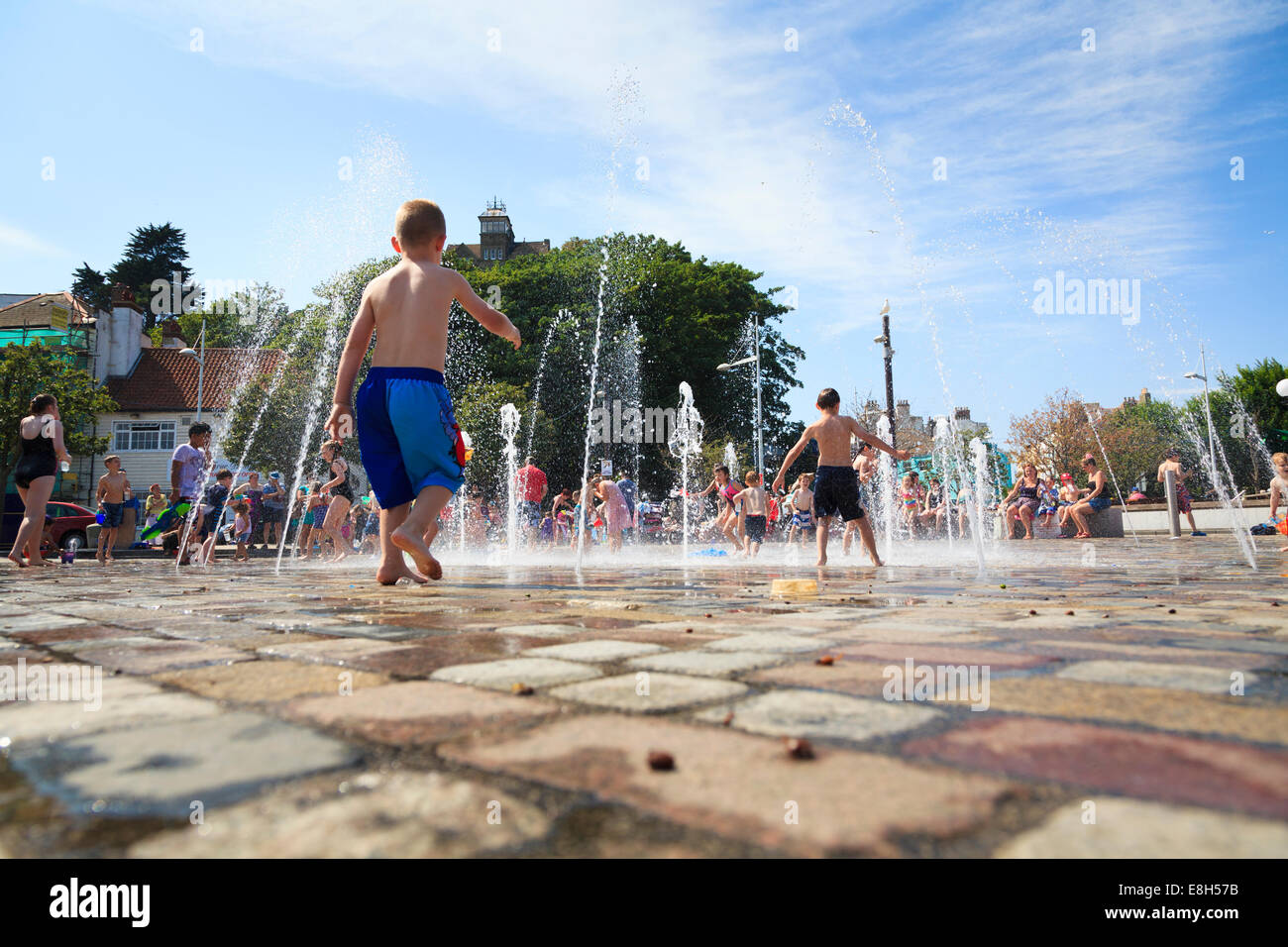 Familien genießen das Wasser Auslauf Brunnen in der Nähe des Hafens in Folkestone. Stockfoto