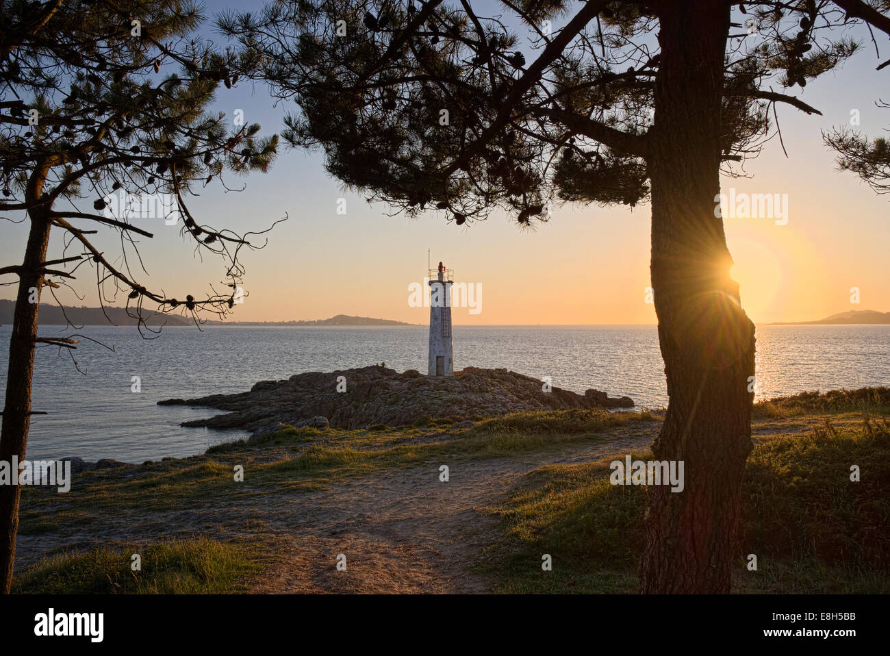 Spanien, Galicien, Leuchtturm am Strand von Leis de Nemancos bei Sonnenuntergang Stockfoto