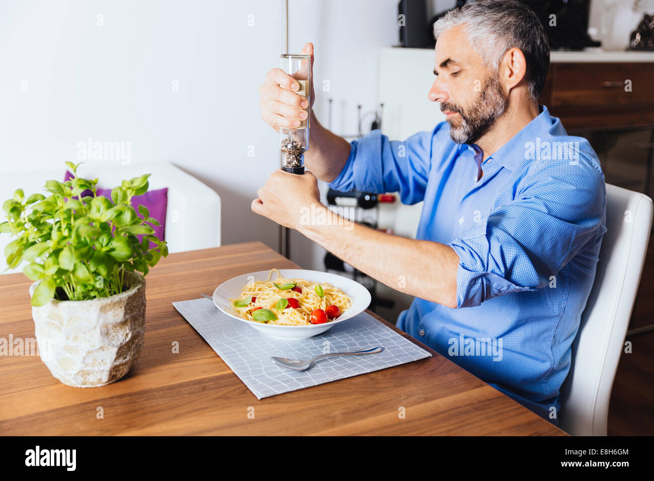 Mann seine Nudeln mit Pfeffer würzen Stockfoto