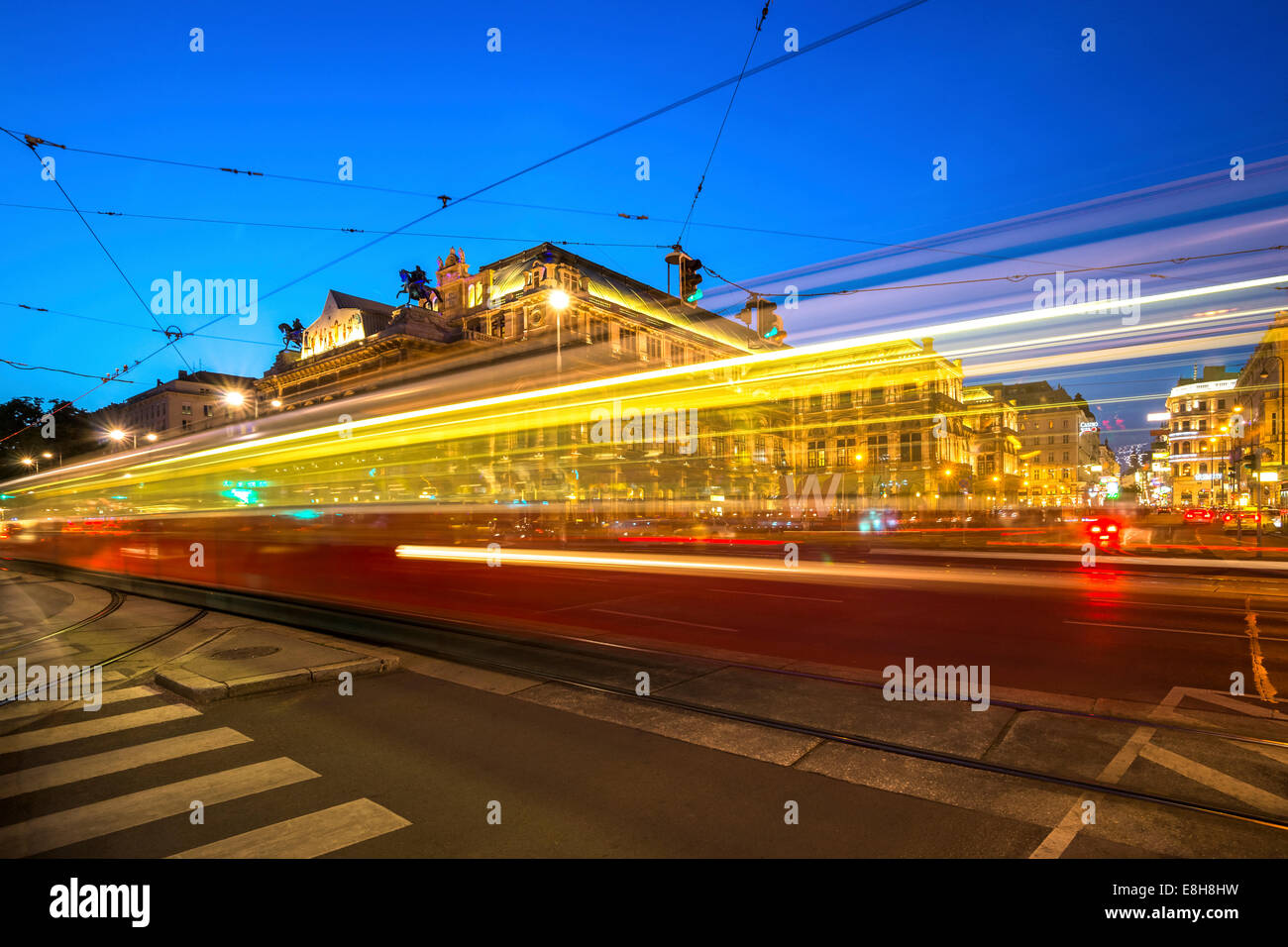 Österreich, Wien, Opernplatz mit vorbeifahrenden Straßenbahn zur blauen Stunde Stockfoto