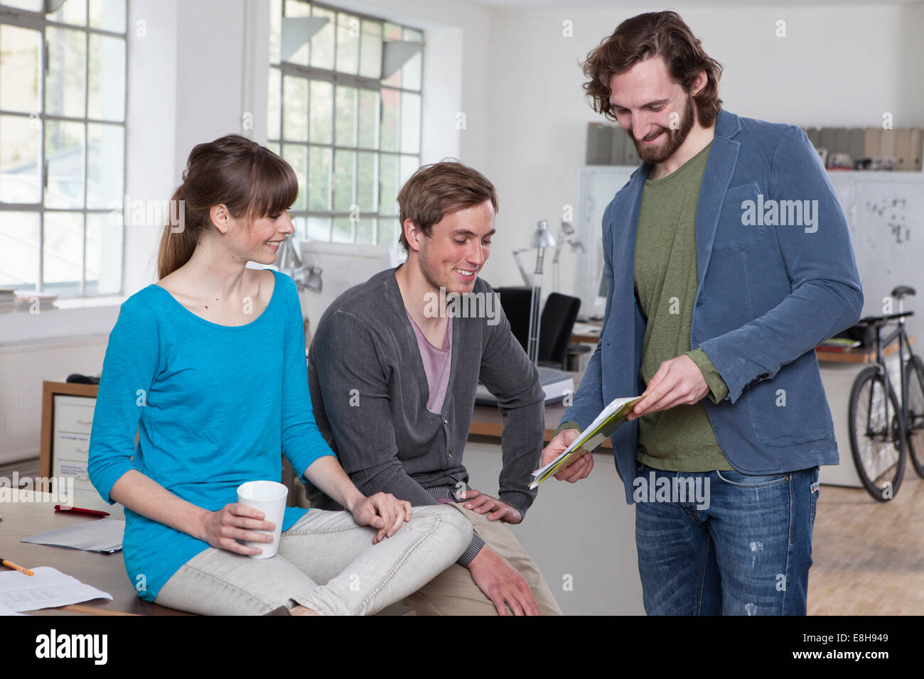 Drei Kollegen diskutieren in einem kreativen Büro Stockfoto