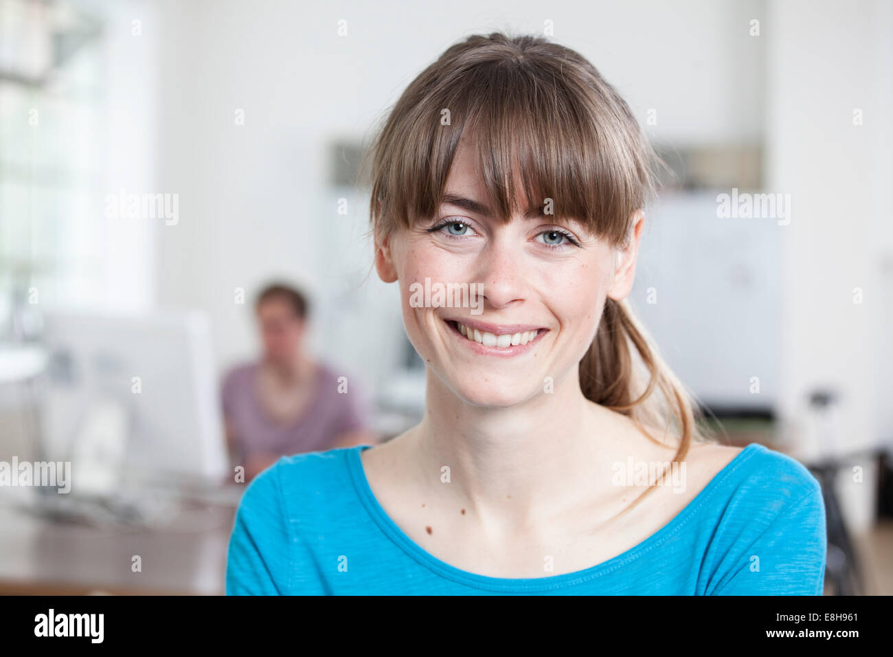 Porträt der lächelnde junge Frau in einem kreativen Büro Stockfoto