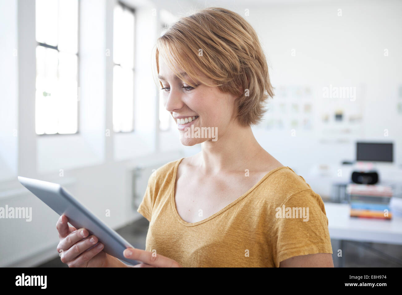 Porträt der lächelnde junge Frau mit digital-Tablette in ein Kreativbüro Stockfoto
