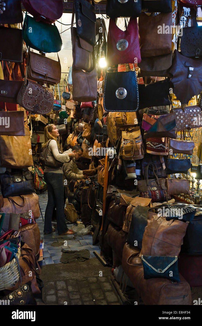 Vertikale Porträt eines westlichen Touristen, die in ein Ledergeschäft Hangbag in den Souks von Marrakesch serviert wird. Stockfoto