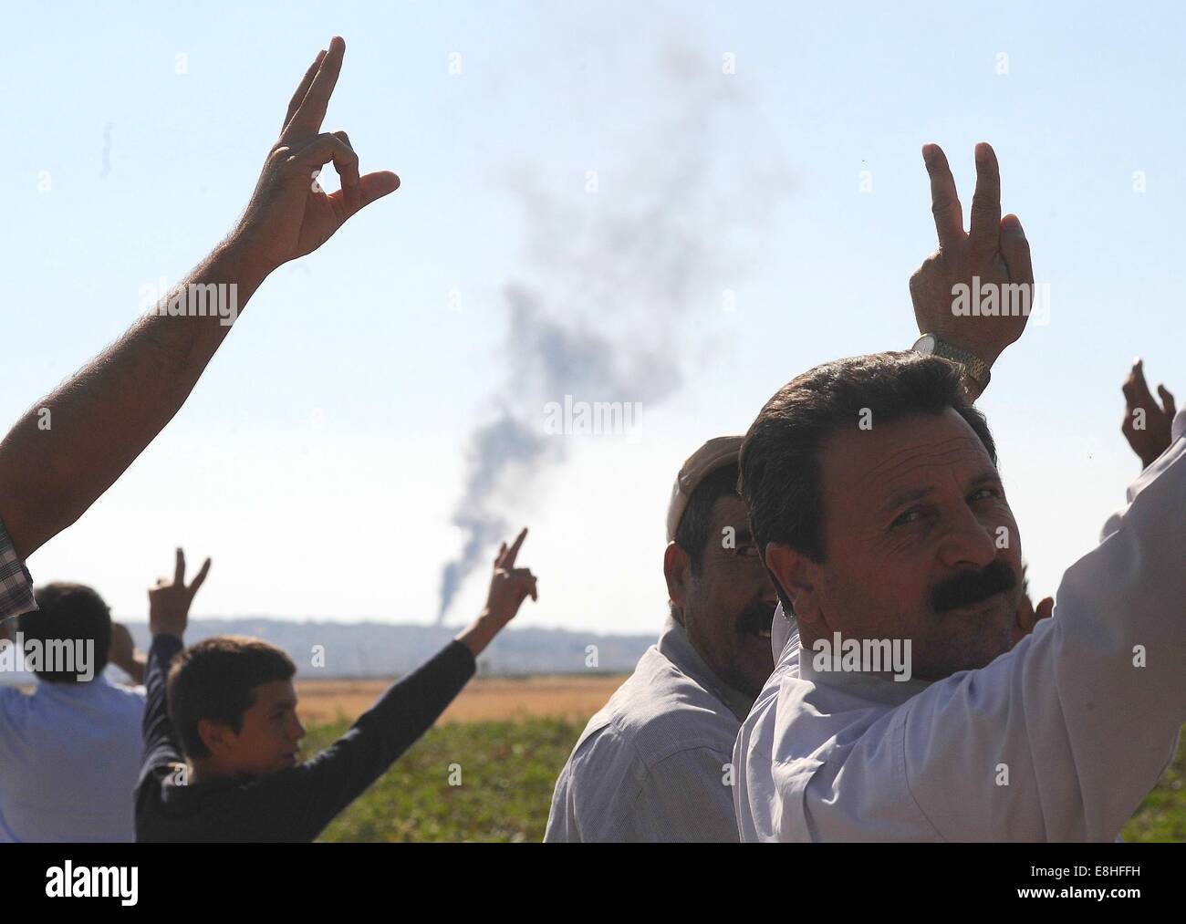 Suruc, Türkei. 8. Oktober 2014. Türkische Kurden jubelten als US militärische hit islamischer Staat Ziele in Kobane Syrien. Hunderte von türkischen Kurden kamen zu Marsitpinar eine Provinz in Suruc, Türkei, über ein Feld in Kobane sehen wo Amerika Luftangriffe gegen den Dschihad Terrorgruppe islamischer Staat geführt hat. © Gail Orenstein/ZUMA Draht/Alamy Live-Nachrichten Stockfoto