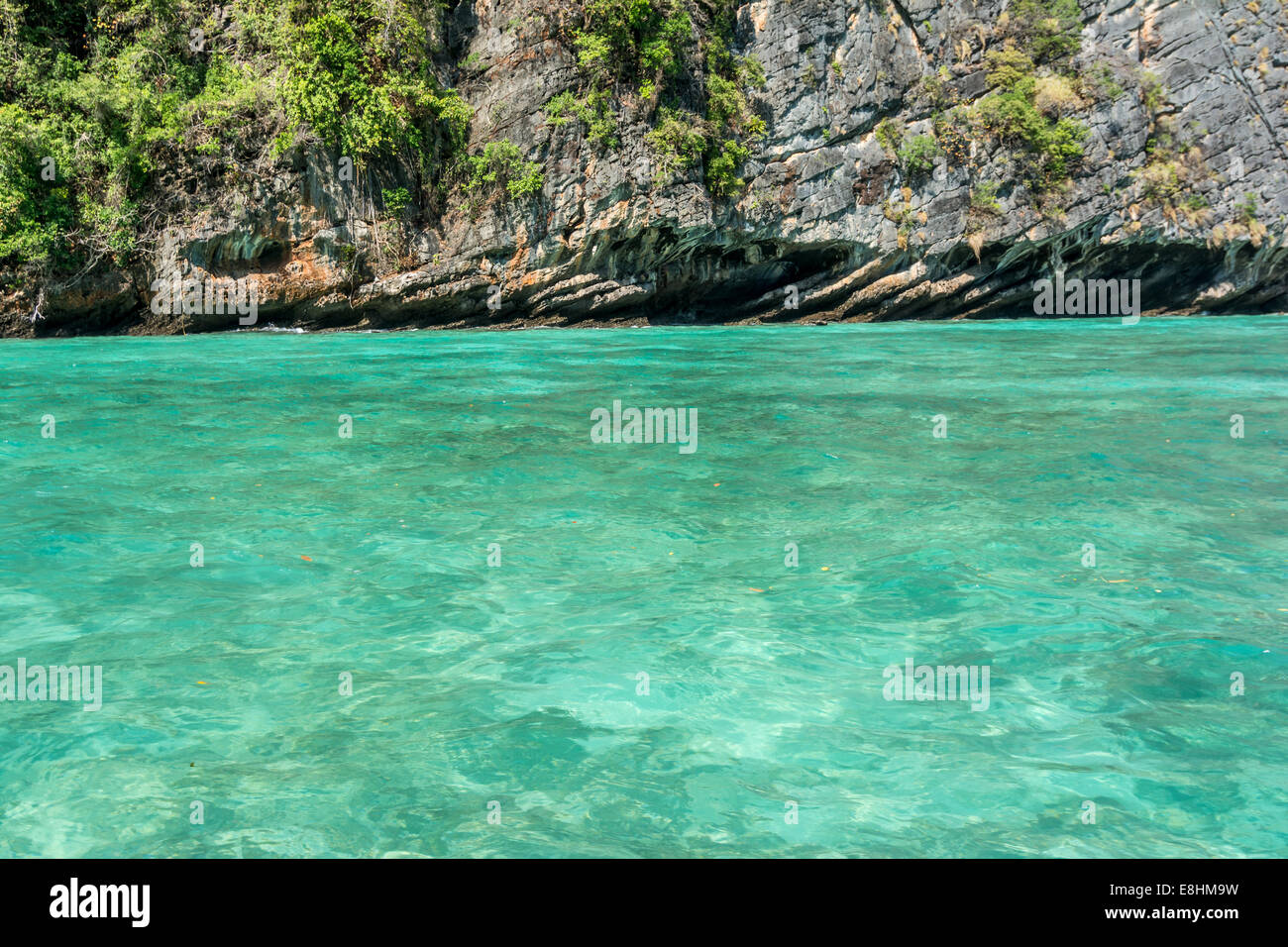 Saubere grüne Smaragdmeer in Thailand mit Felsen im Hintergrund Stockfoto