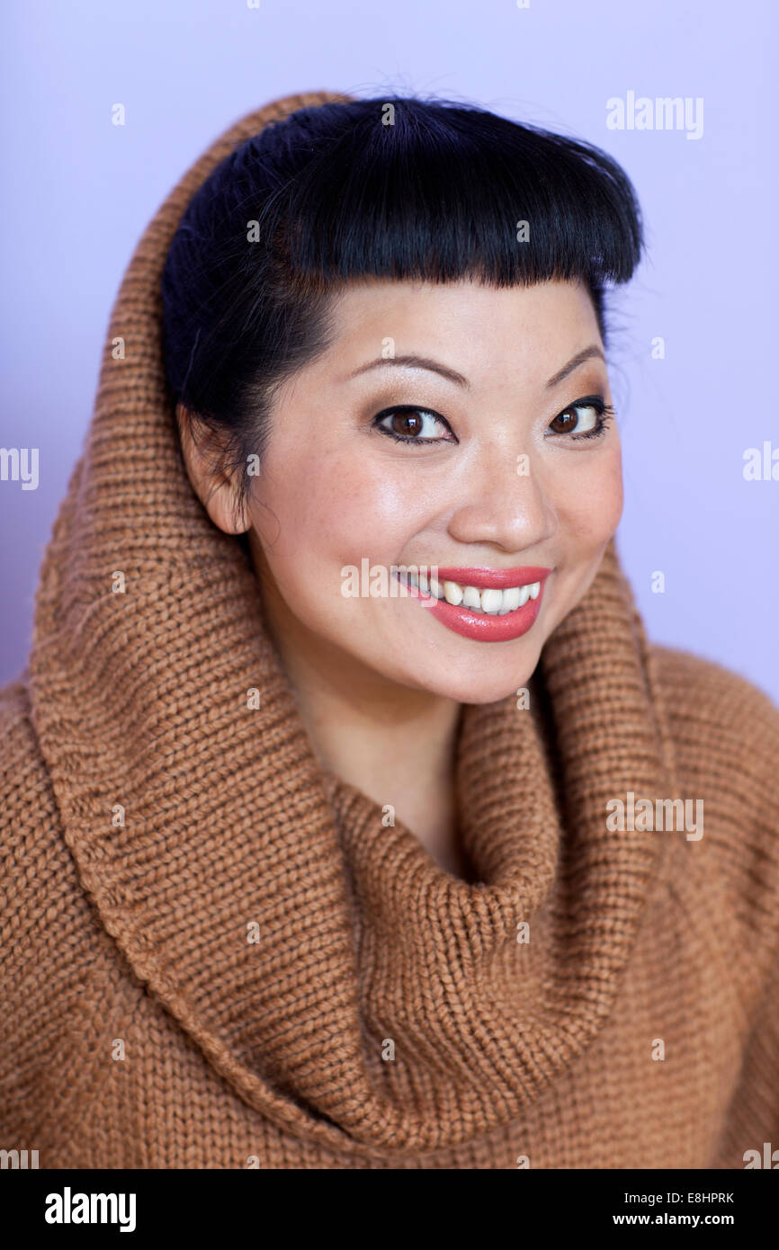Asiatin mit warm fuzzy Kutte Hals Pullover auf. Kurze Haare schneiden mit niedlichen Pony. Stockfoto