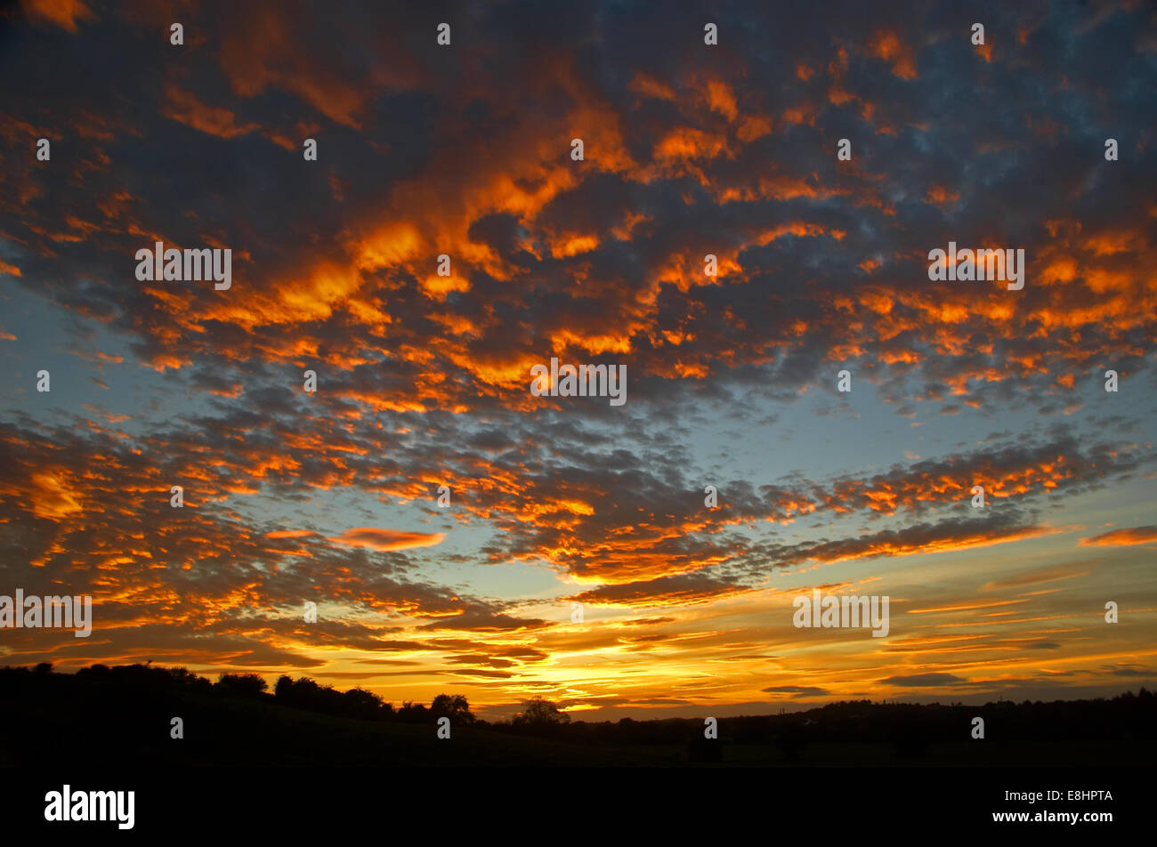 Bunte Abendrot spiegelt sich in einem gebrochenen Himmel von Cumulus-Wolken. Stockfoto