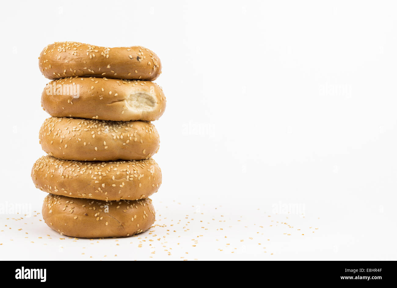 Stapel von Sesam Samen Bagels umgeben von Sesam Stockfoto