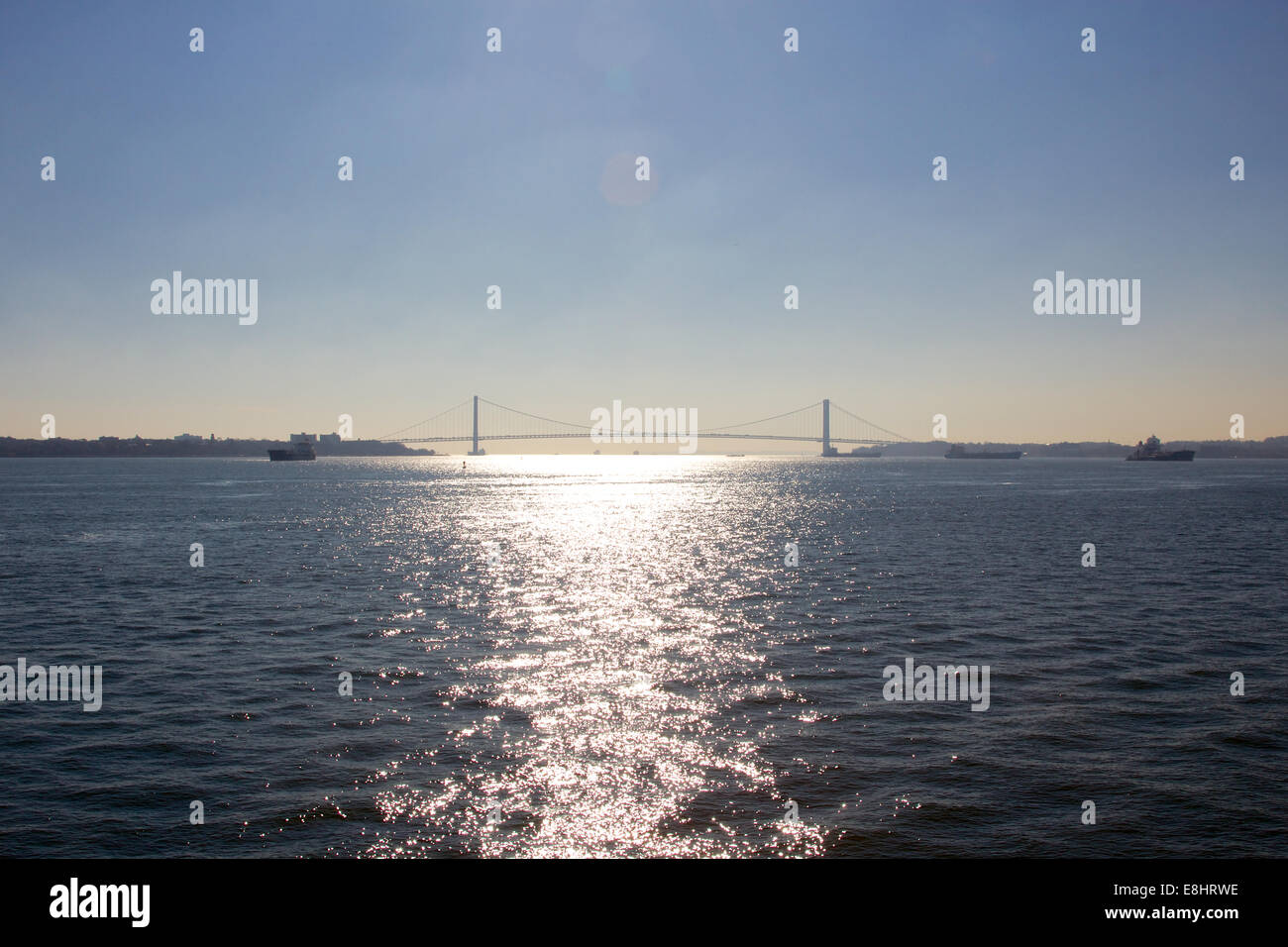 Verrazano-Narrows Bridge zwischen Brooklyn und Staten Island über den schimmernden Wassern bei Sonnenuntergang in New York, NY, USA. Stockfoto