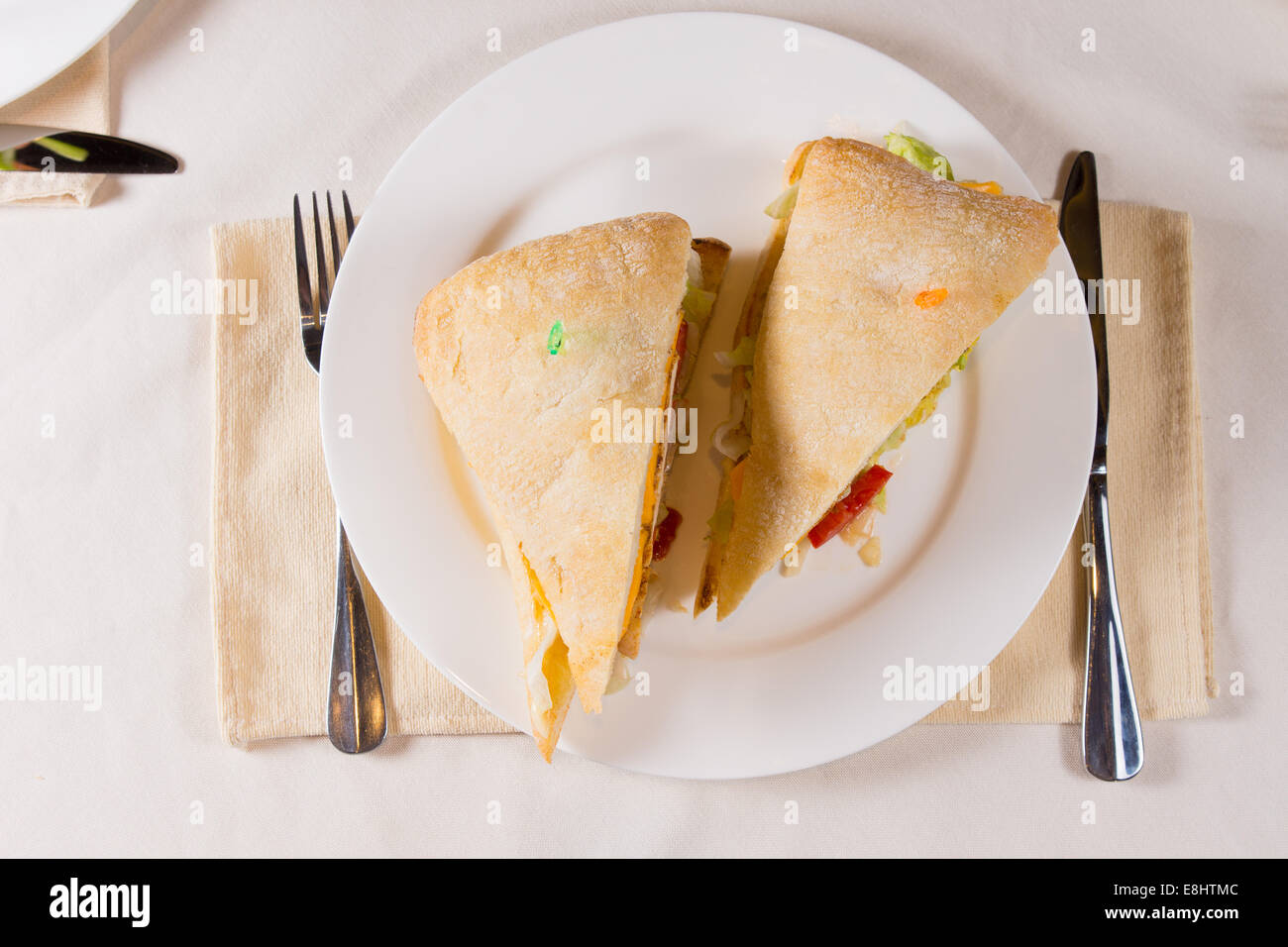 Aufwand für Sandwich auf quadratischen Ciabatta-Brötchen auf Platte im Restaurant Gedeck Stockfoto