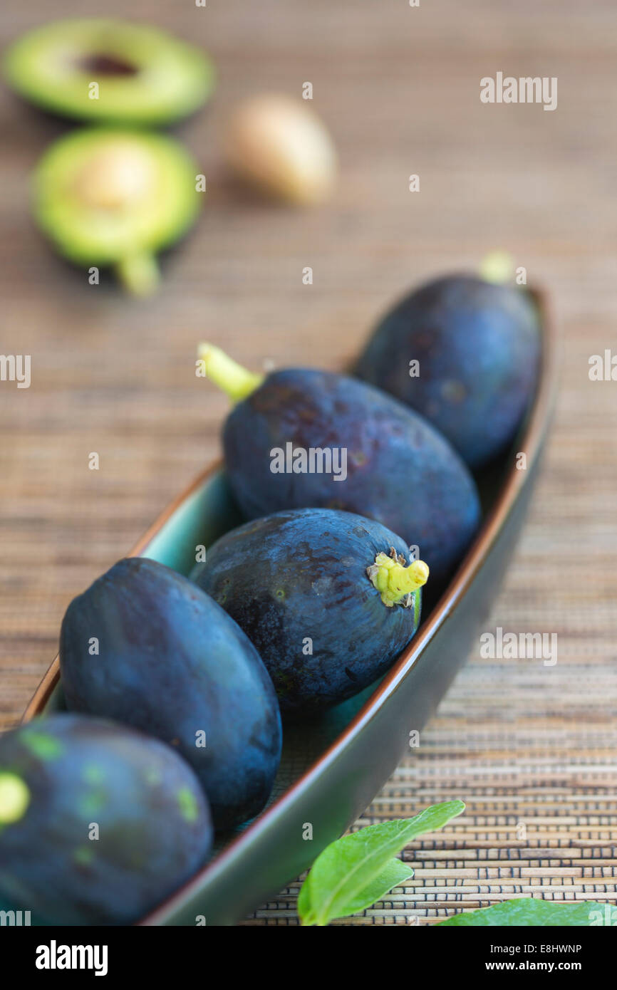 Avocado Früchte in Keramikschale auf gewebte Matte Stockfoto