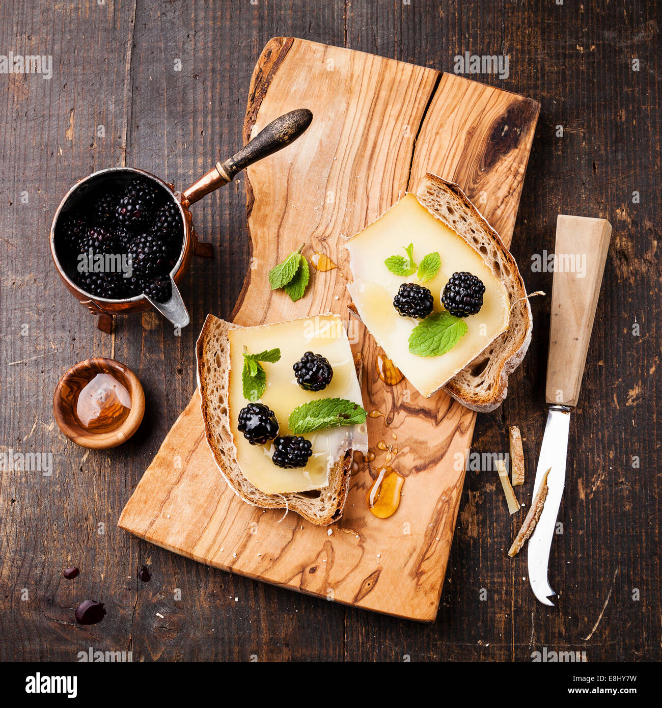 Italienische Bruschetta-Sandwich mit Käse und Blackberry auf frischem Brot auf dunklem Holz Stockfoto