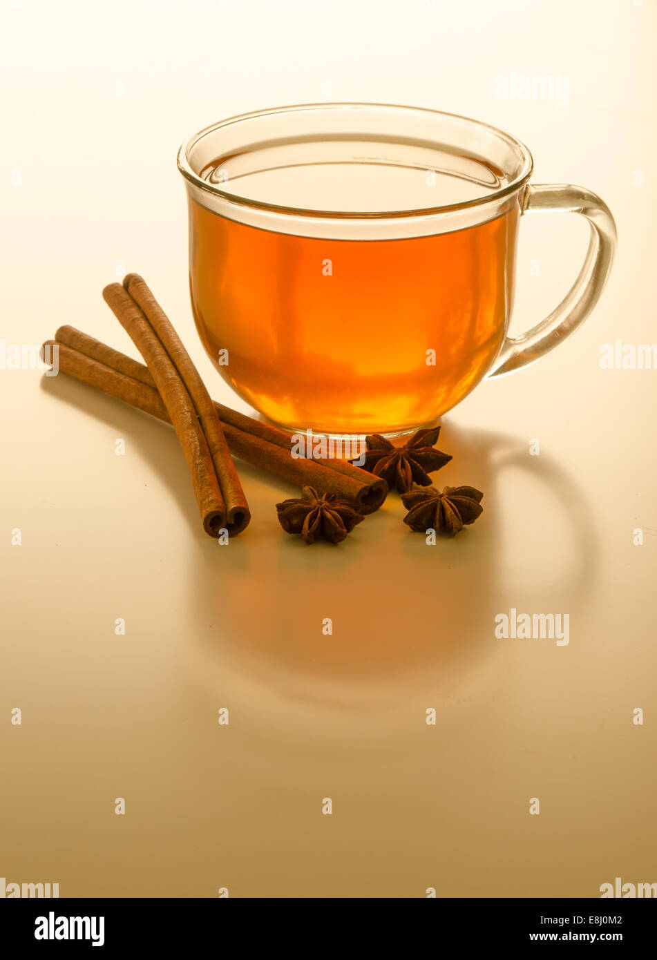 Eine Tasse Chai-Tee auf einer reflektierenden Oberfläche mit Gewürzen Stockfoto