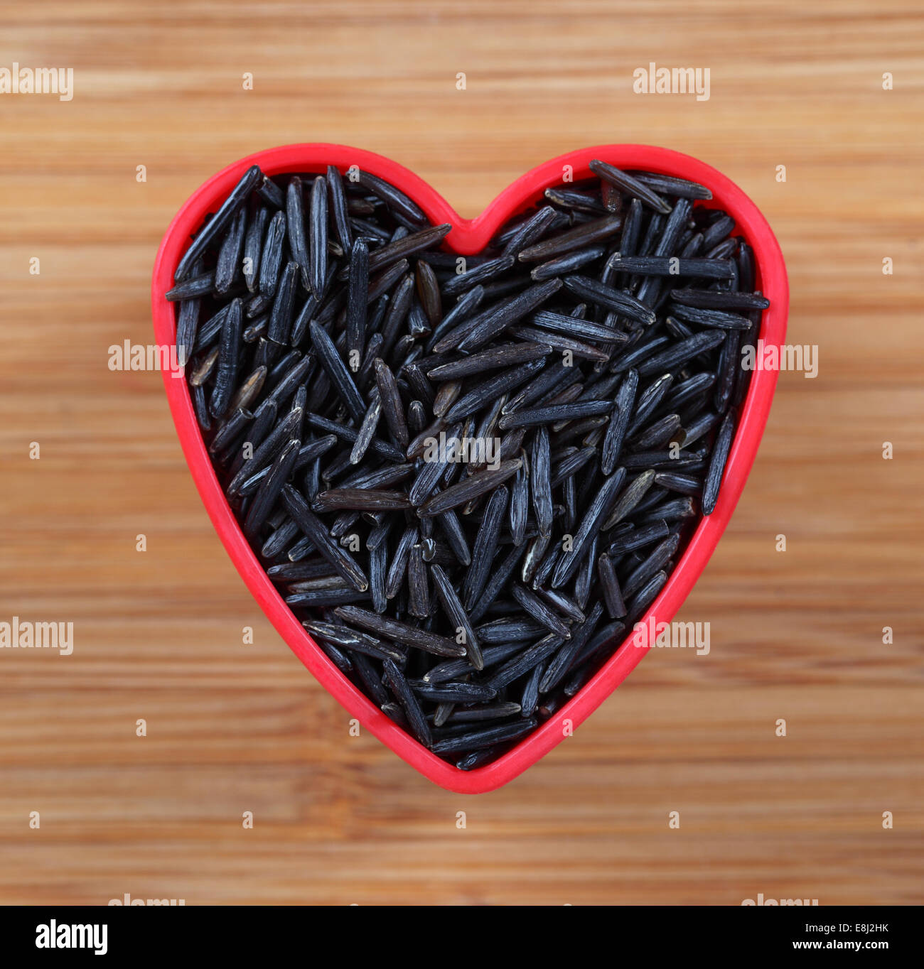 Wilde schwarze Reis in einer Schüssel Herz Form. Close-up. Stockfoto