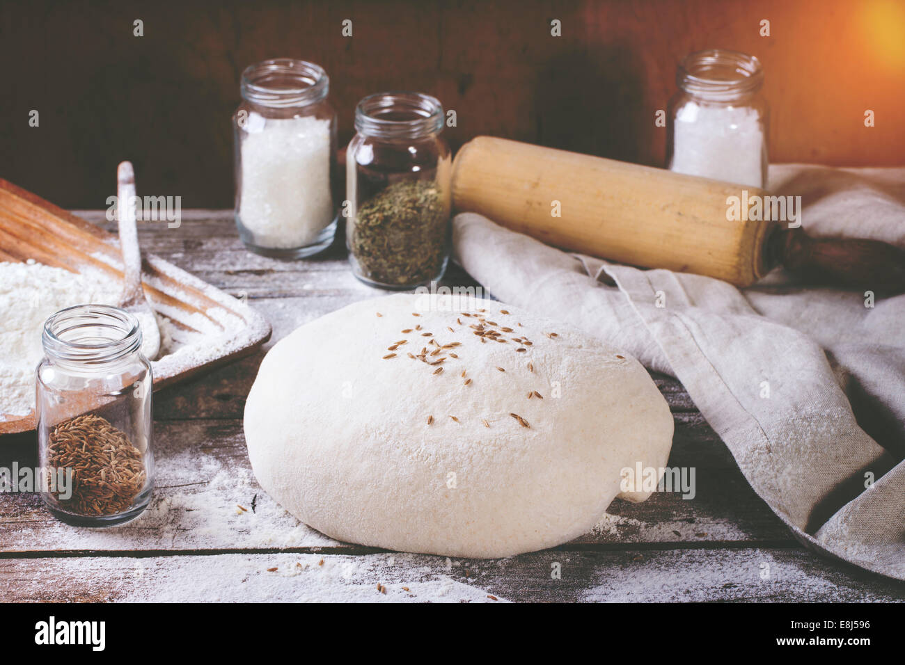 Brot backen. Teig auf Holztisch mit Mehl, Nudelholz und Gläser mit backing-Zutaten. Mit Retro-Filter-Effekt Stockfoto