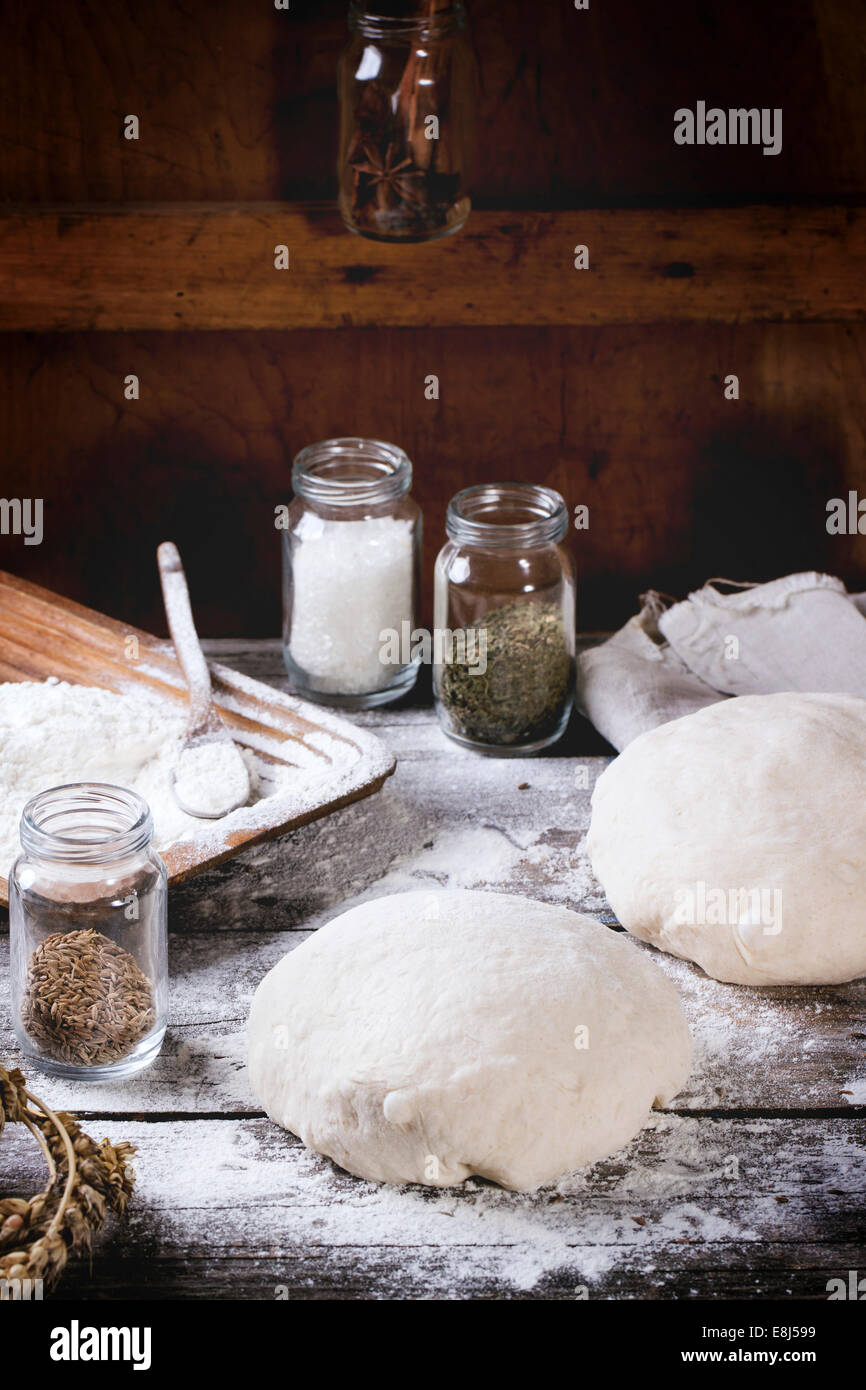 Brot backen. Teig auf Holztisch mit Mehl, Nudelholz und Gläser mit backing-Zutaten. Stockfoto