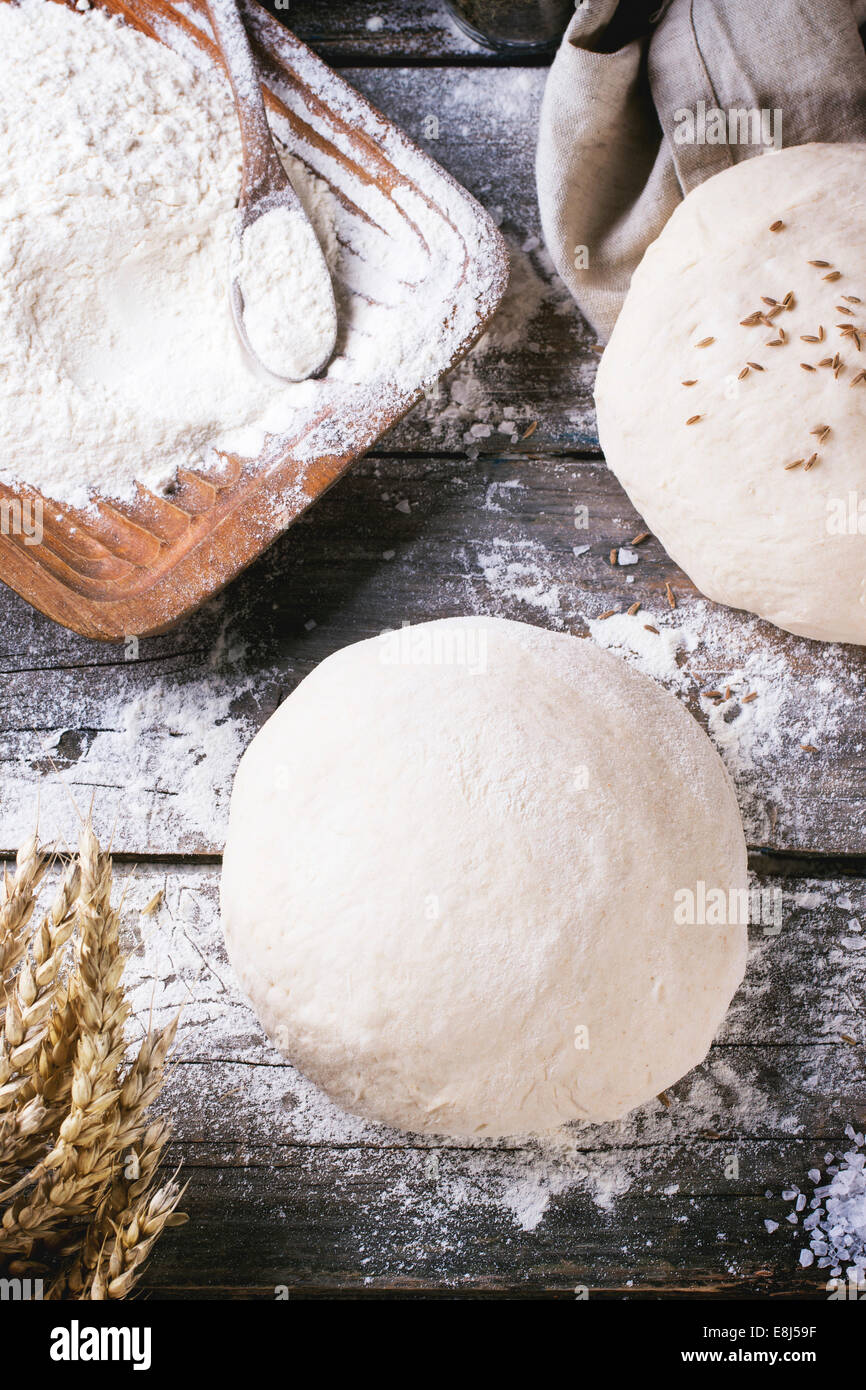 Brot backen. Teig auf Holztisch mit Mehl, Nudelholz und Gläser mit backing-Zutaten. Ansicht von oben Stockfoto
