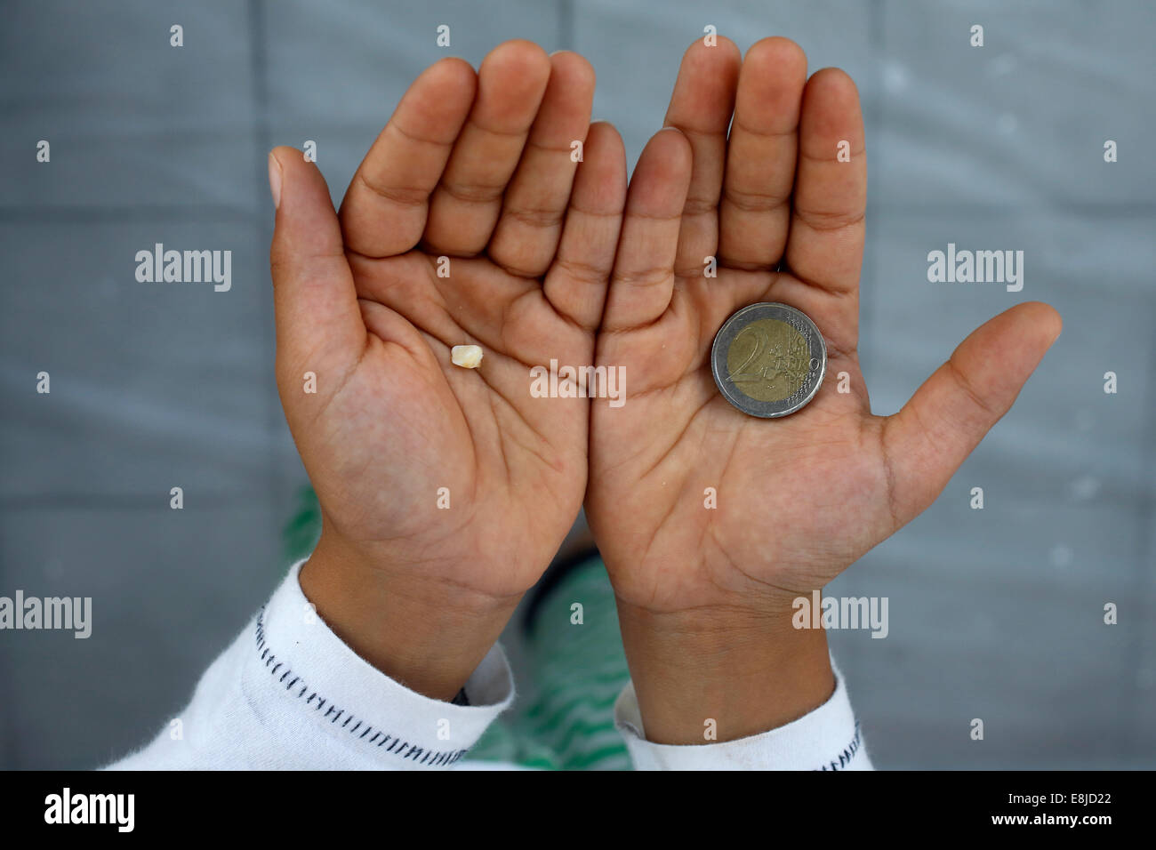 7-Year-Old Boy zeigt einen verlorenen Zahn und Münze Stockfoto