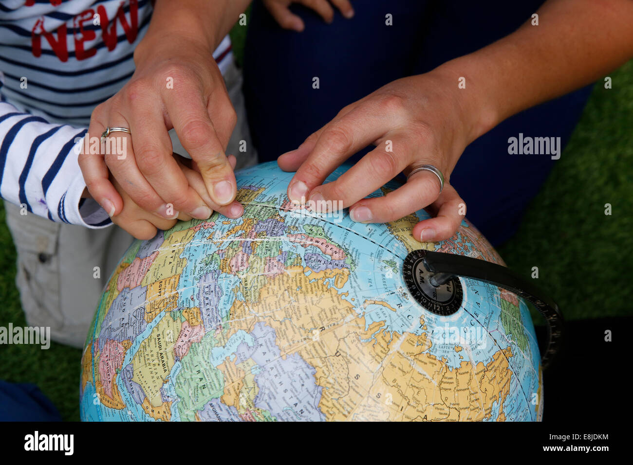 Kindergärtnerin zeigt Länder auf einem Globus Stockfoto
